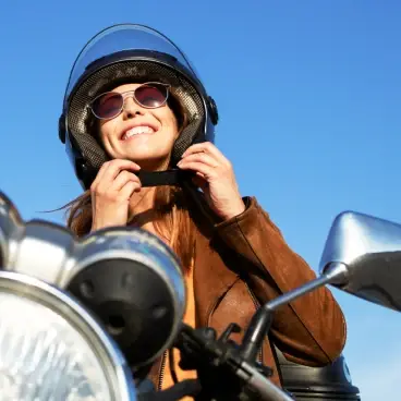 Mulher a conduzir mota em segurança - seguro moto